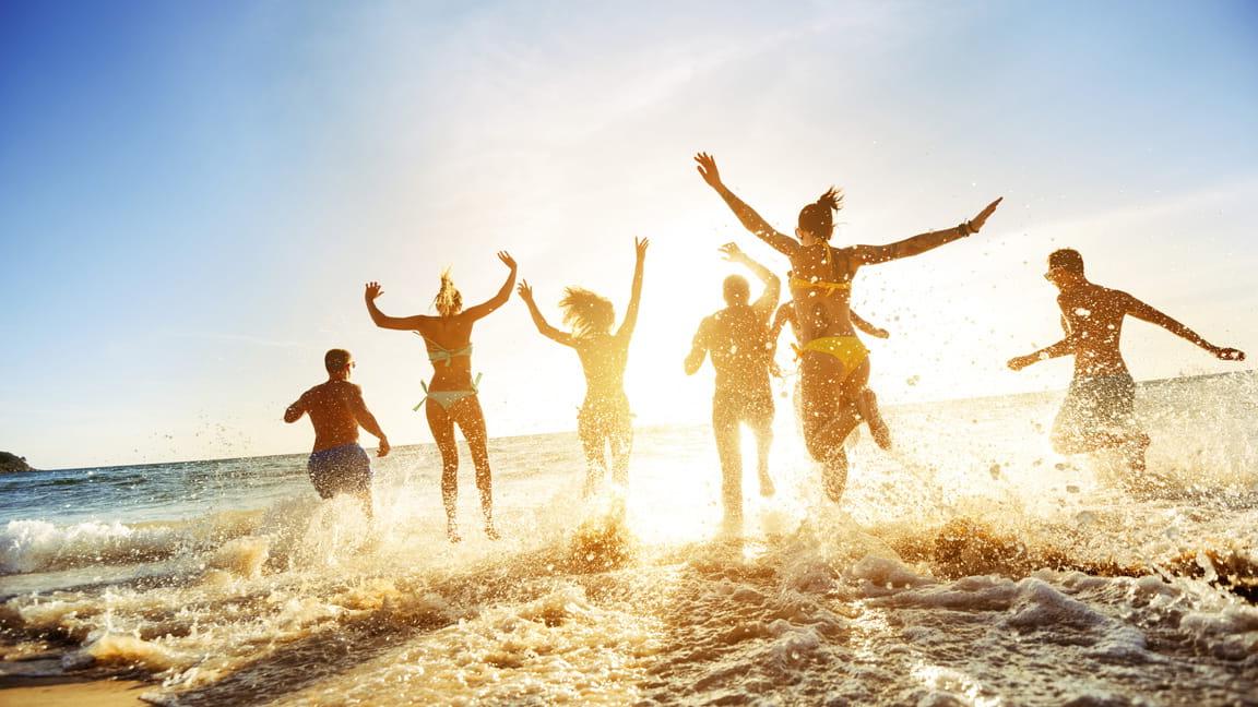 Millennial friends play on beach